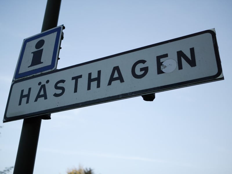 områdesskylt med texten hästhagen i plåt på lyktstolpe